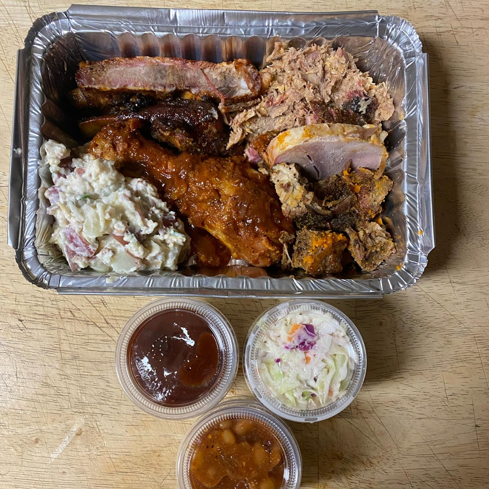 Northwoods Smokin' BBQ platter with ribs, pulled pork, chicken, potato salad, coleslaw, and baked beans.